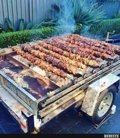 the grill is full of meats and skewers