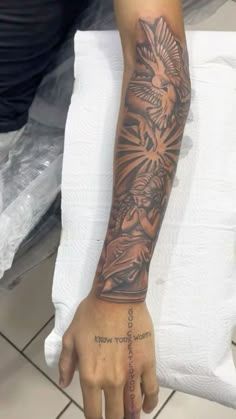 a person with a tattoo on their arm and hand holding something in the other hand