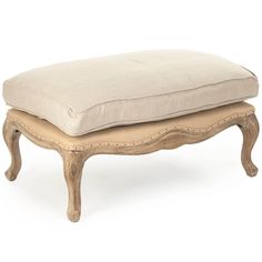 a white ottoman with two pillows on it's legs and one foot resting on the cushion