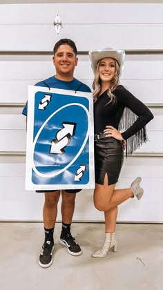 a man and woman dressed up in costumes posing for the camera with a sign on their chest