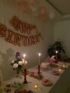 a birthday party with balloons, cake and candles