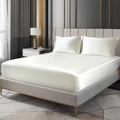 a bed with white sheets and pillows in a room