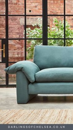 a blue couch sitting in front of a window