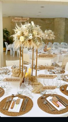 the table is set with silverware and flowers in tall vases on top of burlap place mats