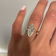 a woman's hand with a ring on it and a diamond in the middle