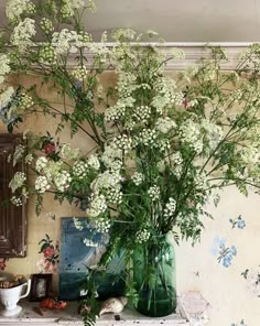 a vase filled with white flowers sitting on top of a table next to a mirror