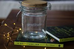 a glass jar sitting on top of a table next to two books with lights around it