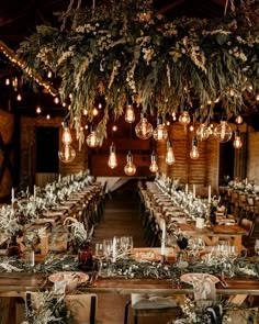 the tables are set with candles, greenery and hanging lights for an elegant wedding reception