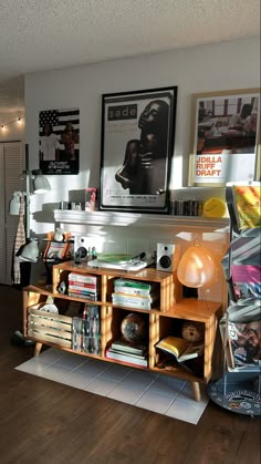 a living room filled with furniture and pictures on the wall next to a table covered in books