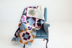 a blue chair with a patchwork quilt on it