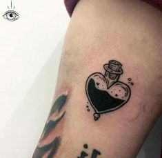 a small tattoo on the leg of a woman with an ink heart and clock in it