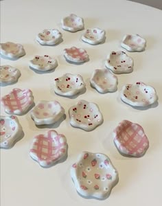 many small pink and white dishes on a table