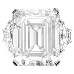 an emerald - cut diamond ring with three diamonds on each side and four prongs