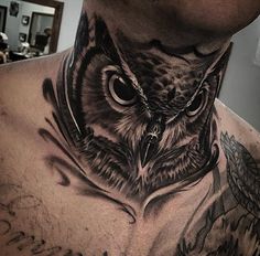 an owl tattoo on the back of a man's neck is shown in black and grey