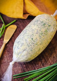 some green onions are sitting on a cutting board next to other vegetables and spoons