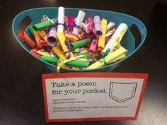 a bowl full of crayons sitting on top of a table next to a sign that says take a poem for your pocket