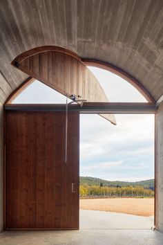 an open wooden door leading to a vineyard