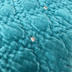 an up close view of a blue blanket with small squares on the top and bottom