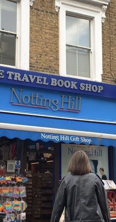 a woman walking past a book shop on the street