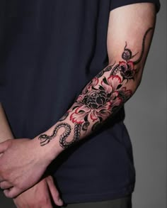 a man with a dragon tattoo on his arm holding onto another person's hand