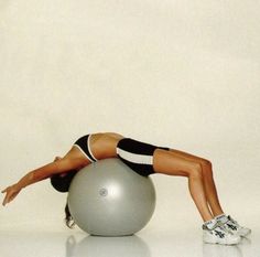 a woman is doing push ups on an exercise ball while holding her leg up in the air