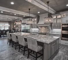 a large kitchen with an island and marble counter tops