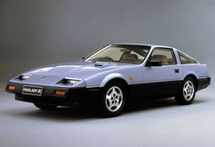 a blue sports car parked in front of a gray background