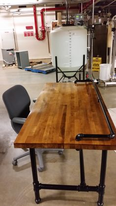 a wooden table sitting in the middle of a room next to two chairs and a water heater