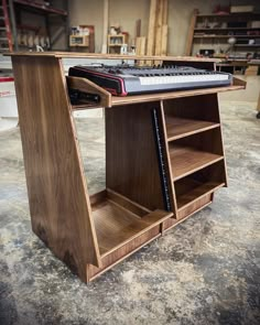 a wooden book shelf with books on it in a garage or workshop area, next to a workbench