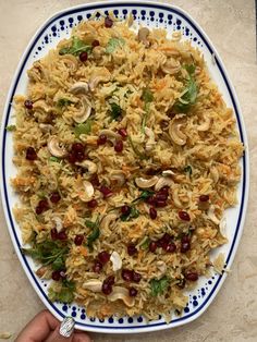 a white plate topped with rice covered in mushrooms and garnished with cranberries