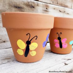 three clay pots with painted butterflies on them