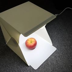 an apple sitting on top of a white piece of paper next to a light fixture