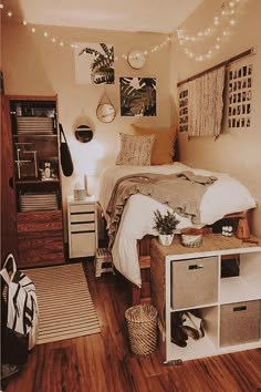 a bedroom decorated in neutral tones with lights strung above the bed and storage boxes on the floor