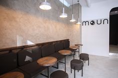 an empty waiting area with benches and stools in front of a wall that reads num