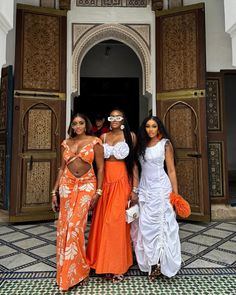 three beautiful women standing in front of a building