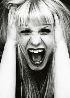 a woman with her hands on her head screaming