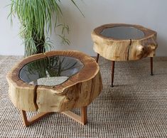 two wooden tables with glass tops on carpeted floor next to potted palm tree