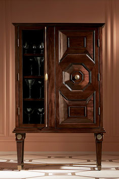 a wooden cabinet with wine glasses in it's door and shelves on either side