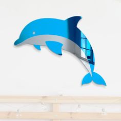 a blue dolphin clock mounted to the side of a white wall next to a window