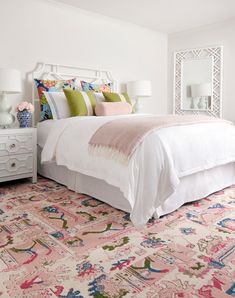 a white bed sitting on top of a pink rug