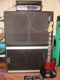 an electric guitar and amp sitting next to each other in front of a wall mounted speaker