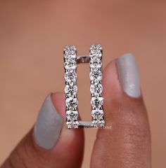 a woman's hand holding an open ring with diamonds on the inside of it