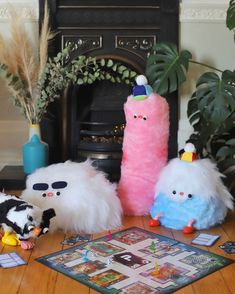 three stuffed animals sitting on top of a wooden table next to a game board and toys