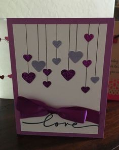 a card with hearts hanging from strings