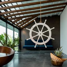 a large white ship wheel hanging from the ceiling in a living room next to a blue couch