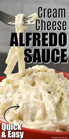 a red bowl filled with cream cheese alfredo sauce and a fork sticking out of it