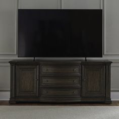 a large flat screen tv mounted to the side of a wooden entertainment center in an empty room