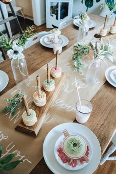 a wooden table topped with plates and cups