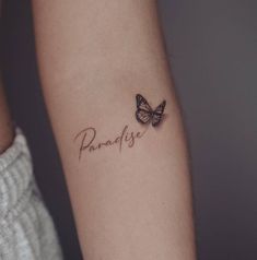 two butterflies with the word paradise tattooed on their arm and behind them is an inscription