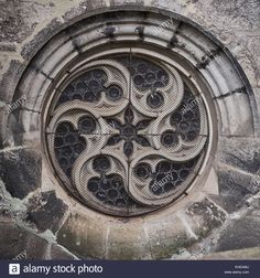 a circular window in the side of a stone building with an intricate design on it